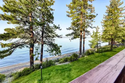 a wooden path next to a beach with trees at Our Lake House in Zephyr Cove
