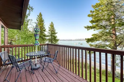 a table and chairs on a deck with a view of the water at Our Lake House in Zephyr Cove