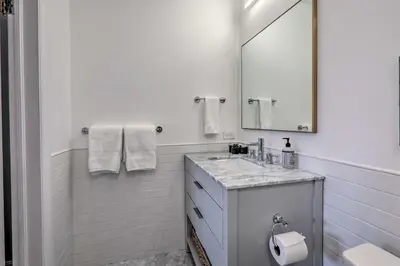 a white bathroom with a sink and a mirror at Reno Home Less Than 1 Mile to Midtown and Truckee River in Reno