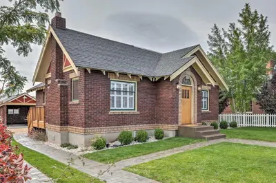 a red brick house with a white fence at Reno Home Less Than 1 Mile to Midtown and Truckee River in Reno
