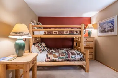 a bedroom with two bunk beds and a desk at Snowcreek V 963 in Mammoth Lakes