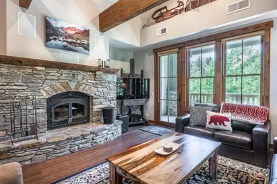 a living room with a stone fireplace at Lodges 1138 in Mammoth Lakes