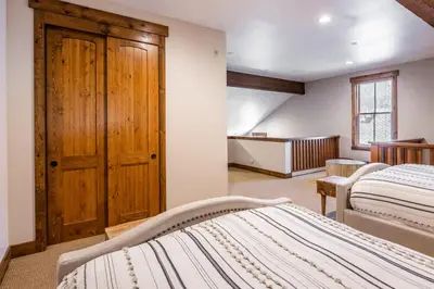 a bedroom with two beds and a wooden door at Lodges 1138 in Mammoth Lakes