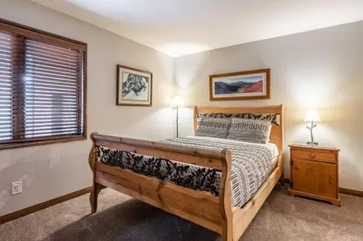 a bedroom with a wooden bed and a window at Helios 9N in Mammoth Lakes