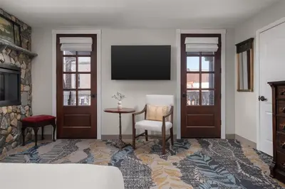 a living room with a television and a table and chairs at National Hotel Jackson, Tapestry Collection by Hilton in Jackson