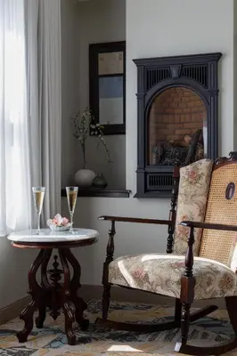 a living room with a table and a chair and a fireplace at National Hotel Jackson, Tapestry Collection by Hilton in Jackson