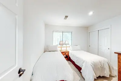 two beds in a bedroom with white walls at Grey Fireplace in Truckee