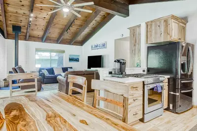 a kitchen and living room with a stove and a couch at The Lazy Golden Cabin in South Lake Tahoe