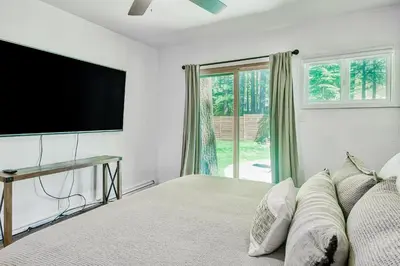 a bedroom with a large bed with a flat screen tv at The Lazy Golden Cabin in South Lake Tahoe