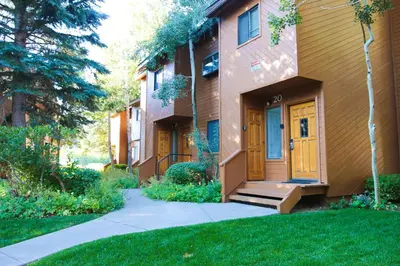 a house with yellow doors and a sidewalk at Snowflower #20 condo in Mammoth Lakes