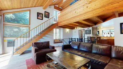 a living room with a couch and a staircase at Snowflower #20 condo in Mammoth Lakes