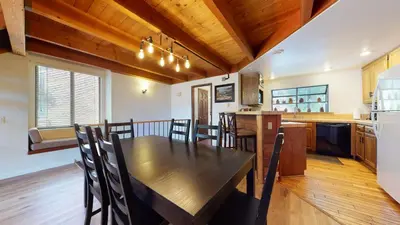 a kitchen and dining room with a wooden table and chairs at Snowflower #20 condo in Mammoth Lakes