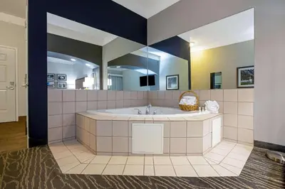 a large bathroom with a tub and a large mirror at La Quinta by Wyndham Manteca - Ripon in Ripon