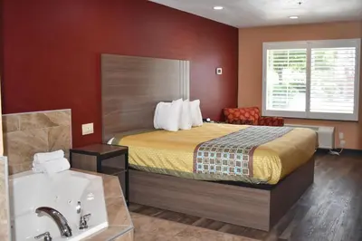 a hotel room with a bed and a bath tub at Baymont by Wyndham Manteca in Manteca