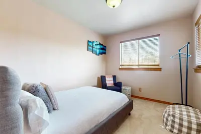 a bedroom with a bed and a chair and a window at Truckee Living in Truckee