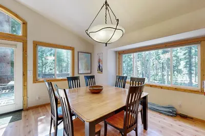 a dining room with a wooden table and chairs at Sugar Pine Haus in Tahoma