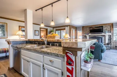 a kitchen with a sink and a living room at Brand New Listing! 5 minute walk to Canyon Lodge! Newly Updated Two-Bed, Two-Bath, Mountainback #14 in Mammoth Lakes