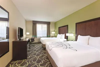 a hotel room with two beds and a flat screen tv at La Quinta by Wyndham Los Banos in Los Banos