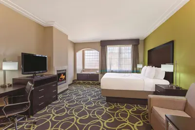 a hotel room with a bed and a flat screen tv at La Quinta by Wyndham Los Banos in Los Banos