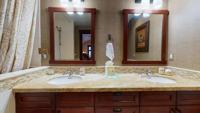 a bathroom with two sinks and two mirrors at Juniper Crest #24 townhouse in Mammoth Lakes