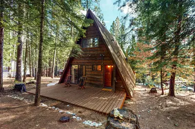 a cabin in the woods with a wooden deck at Heavenly Daze in Arnold