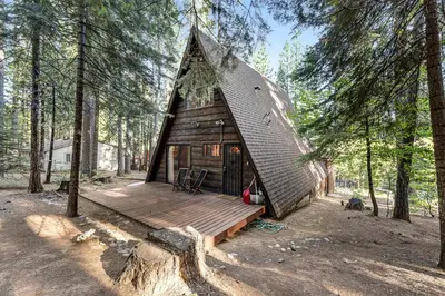 a cabin in the woods with a wooden deck at Heavenly Daze in Arnold