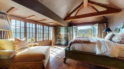 a bedroom with a bed and a couch and windows at Juniper Ridge #16 home in Mammoth Lakes