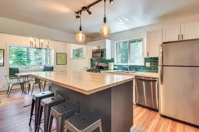 a kitchen with a large island with bar stools at Cozy Retreat with Deck about 2 Mi to Pinecrest Lake! in Strawberry