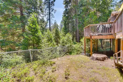 a tree house with a deck in the woods at Cozy Retreat with Deck about 2 Mi to Pinecrest Lake! in Strawberry