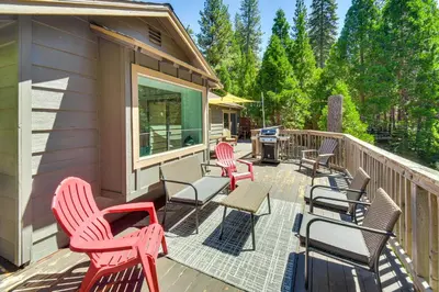 a deck with chairs and tables and a grill at Cozy Retreat with Deck about 2 Mi to Pinecrest Lake! in Strawberry