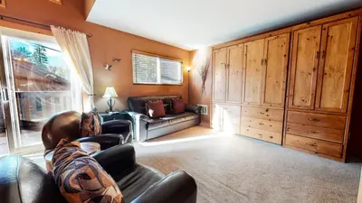 a living room with a couch and a chair and a window at Mammoth View Villas #3 condo in Mammoth Lakes