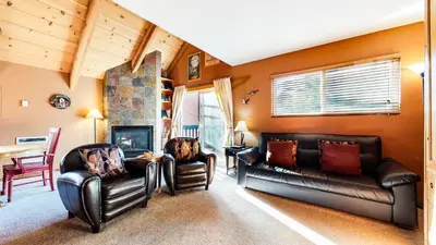 a living room with two leather couches and a fireplace at Mammoth View Villas #3 condo in Mammoth Lakes