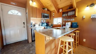a kitchen with a counter with stools and a sink at Mammoth View Villas #3 condo in Mammoth Lakes