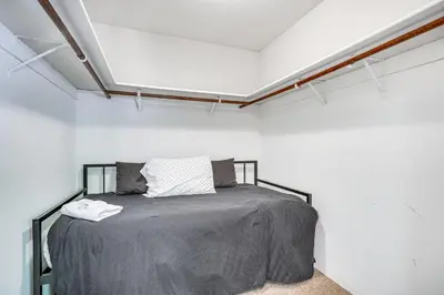a bedroom with a bed in a white room at Arnold Family Cabin with Hot Tub, Arcade and Deck in Arnold