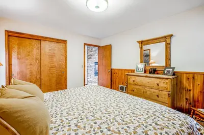 a bedroom with a bed and a dresser and a mirror at Worth The Waite in Arnold