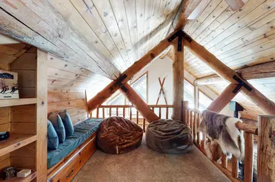 a room in a log cabin with a blue couch at Kia Ora Northwoods in Truckee