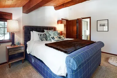 a bedroom with a large bed with a blue blanket at Kia Ora Northwoods in Truckee