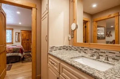 a bathroom with a sink and a mirror and a bedroom at New Listing Updated 1 bedrm 1 bath Summit H Building #95 condo Just steps to Eagle Lodge sleeps 4 in Mammoth Lakes