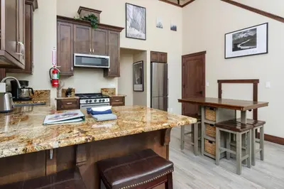 a kitchen with wooden cabinets and a granite counter top at Devonshire - Aberdeen in Yosemite West