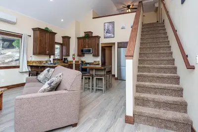 a living room with a staircase and a couch at Devonshire - Aberdeen in Yosemite West