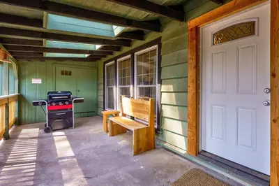 a porch with a white door and a grill at Cedar Nest in Wawona