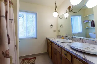 a bathroom with two sinks and a large mirror at Cedar Nest in Wawona