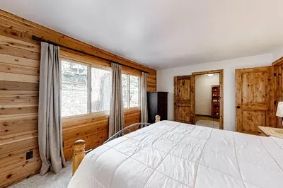 a bedroom with a bed and wooden walls and a window at Ski Run Villas 8 in Mammoth Lakes