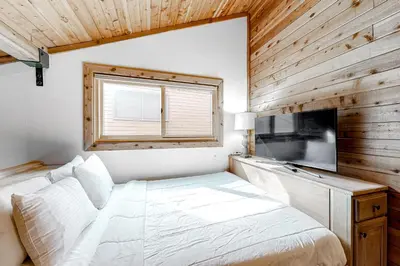 a bedroom with a white bed and a television at Ski Run Villas 8 in Mammoth Lakes