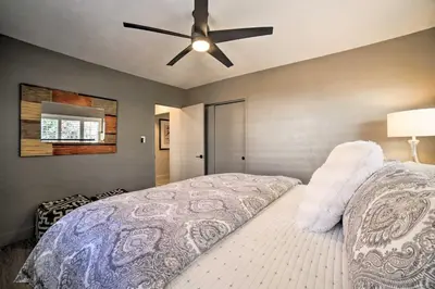 a bedroom with a bed with a ceiling fan at Game Room and Putting Green Reno Home! in Reno