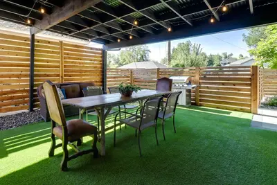 a patio with a wooden fence and a table and chairs at Game Room and Putting Green Reno Home! in Reno