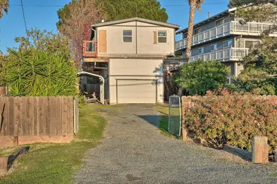 a house with a garage and a fence at Bethel Island Sanctuary with Dock and Boathouse in Oakley