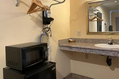 a bathroom with a tv on a counter with a sink at Sunstar Inn Los Banos near I-5 in Los Banos