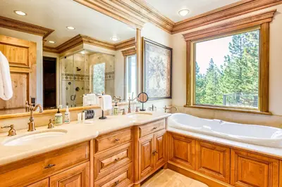a bathroom with a tub and a large window at Alpine Luxury in Zephyr Cove