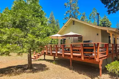 a house with a large deck with an umbrella at Redwood Escape in Arnold